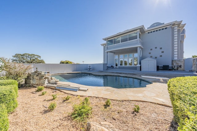 view of pool featuring a diving board, cooling unit, and a patio area