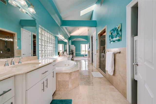 bathroom with vaulted ceiling with skylight, vanity, and independent shower and bath