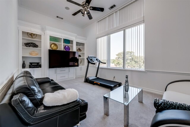 living area featuring a ceiling fan, light colored carpet, and built in features