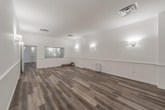 unfurnished room featuring dark wood-type flooring and baseboards