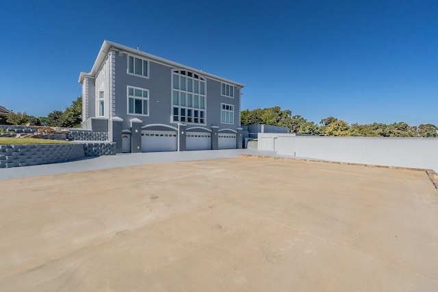 view of property exterior featuring fence and an attached garage