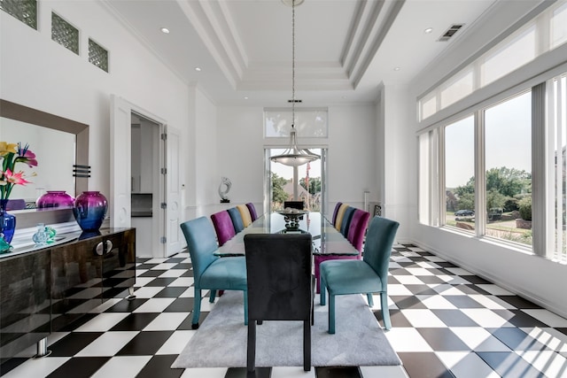 dining room featuring tile patterned floors, healthy amount of natural light, a high ceiling, a raised ceiling, and baseboards