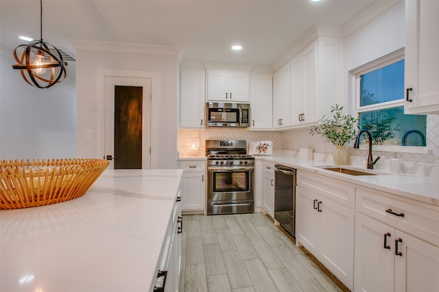 kitchen featuring white cabinets, appliances with stainless steel finishes, backsplash, and sink