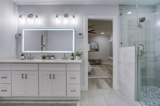 bathroom featuring hardwood / wood-style floors, vanity, ceiling fan, and a shower with shower door