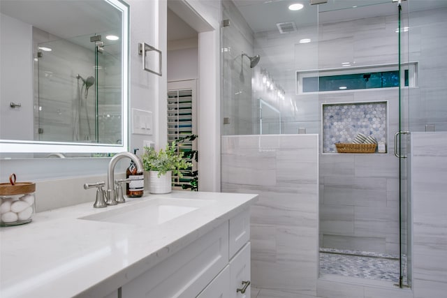 bathroom featuring vanity and a shower with shower door