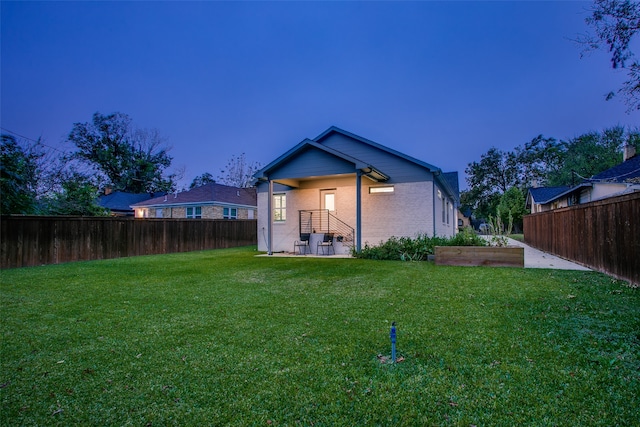 back house at dusk with a yard