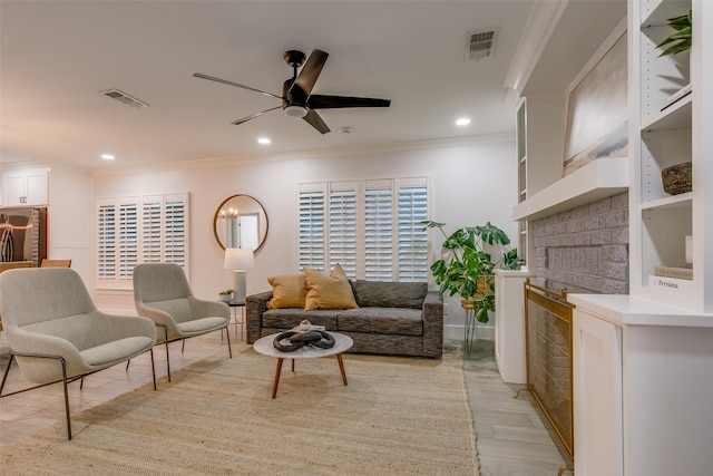 living room with crown molding, light hardwood / wood-style flooring, and ceiling fan