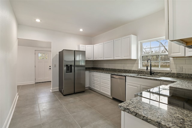 kitchen with stainless steel appliances, white cabinets, sink, and backsplash