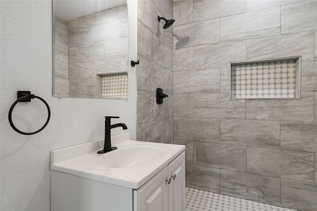 bathroom featuring vanity and tiled shower