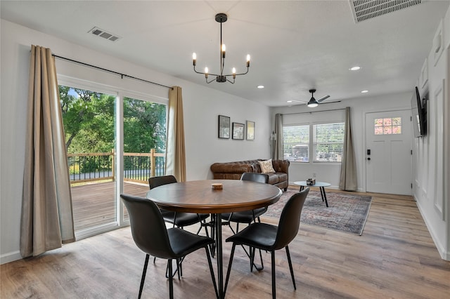 dining room featuring ceiling fan with notable chandelier and light wood-type flooring