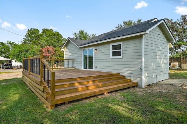 rear view of property with a wooden deck and a lawn