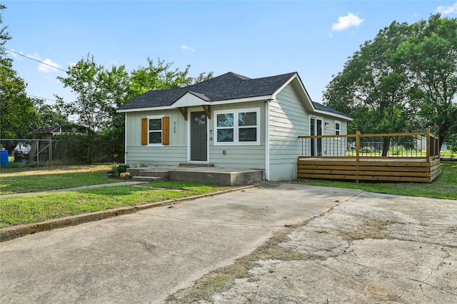 bungalow-style house featuring a front lawn and a deck