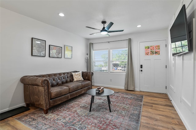 living room featuring dark wood-type flooring and ceiling fan