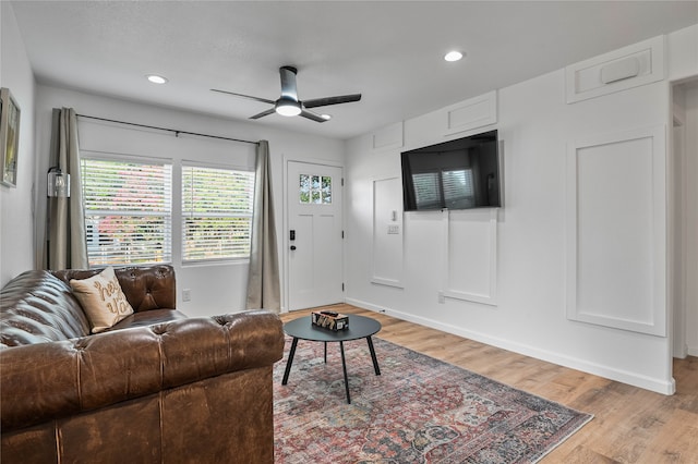 living room with light hardwood / wood-style floors and ceiling fan