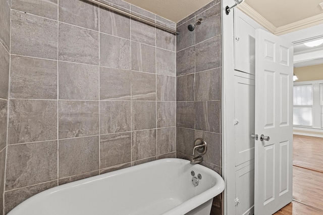 bathroom with ornamental molding, hardwood / wood-style floors, a textured ceiling, and shower / bathing tub combination