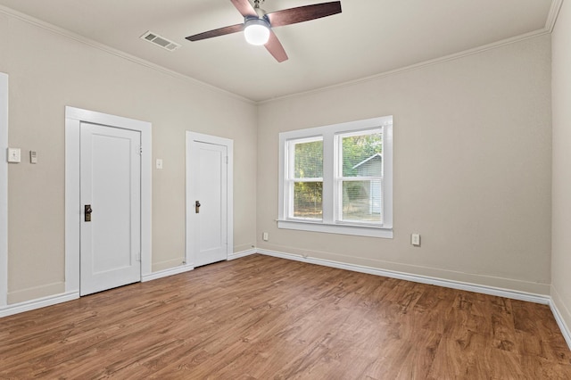 unfurnished room with ceiling fan, light wood-type flooring, and ornamental molding