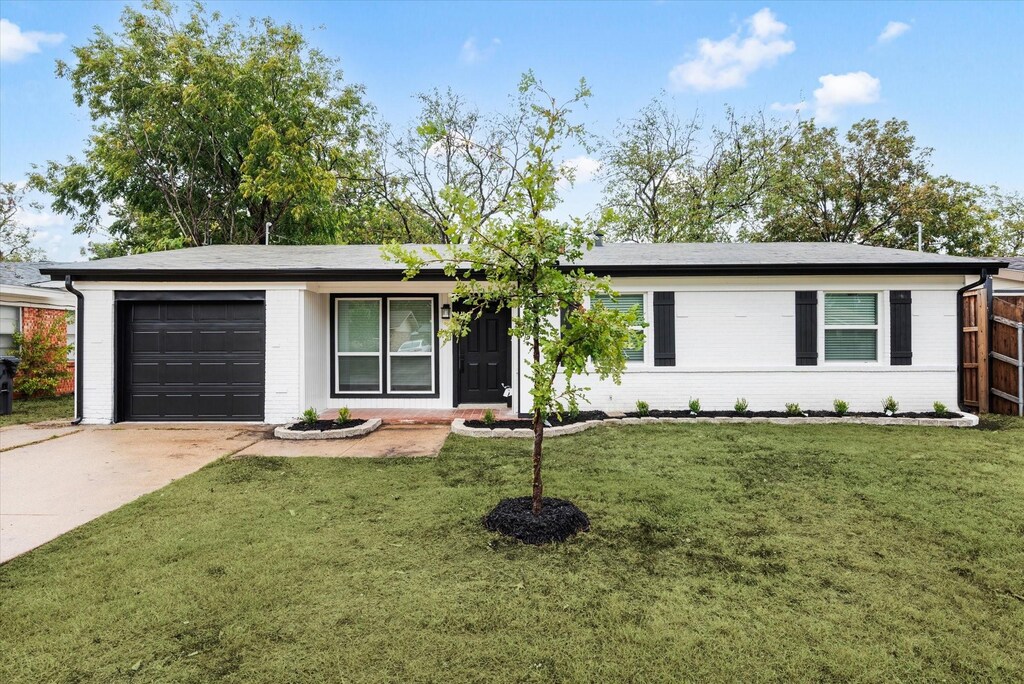 ranch-style house featuring a front yard and a garage