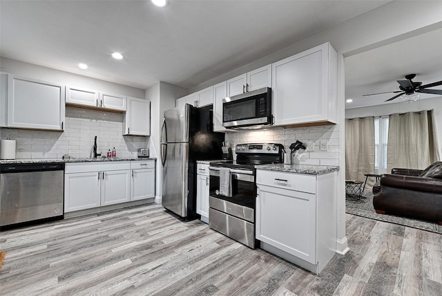 kitchen featuring sink, light hardwood / wood-style flooring, white cabinets, and appliances with stainless steel finishes