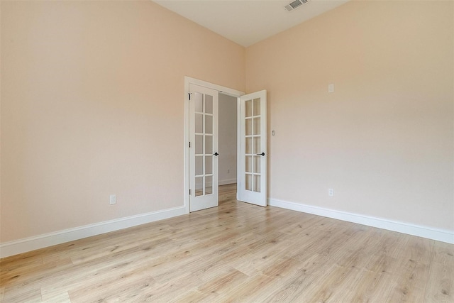 unfurnished room with french doors and light hardwood / wood-style flooring