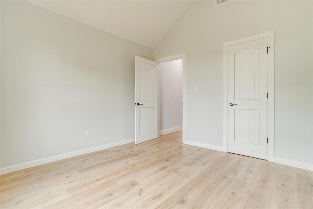 unfurnished bedroom with high vaulted ceiling and light hardwood / wood-style flooring