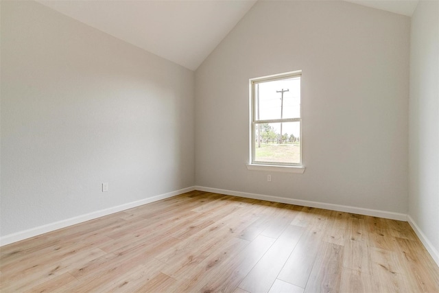 empty room featuring light hardwood / wood-style floors and high vaulted ceiling