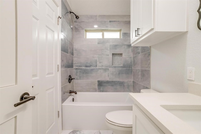 full bathroom featuring vanity, tiled shower / bath combo, and toilet