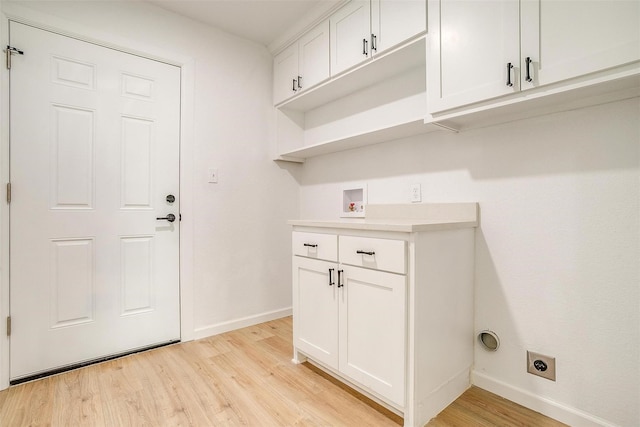 laundry room with electric dryer hookup, cabinets, hookup for a washing machine, and light hardwood / wood-style floors