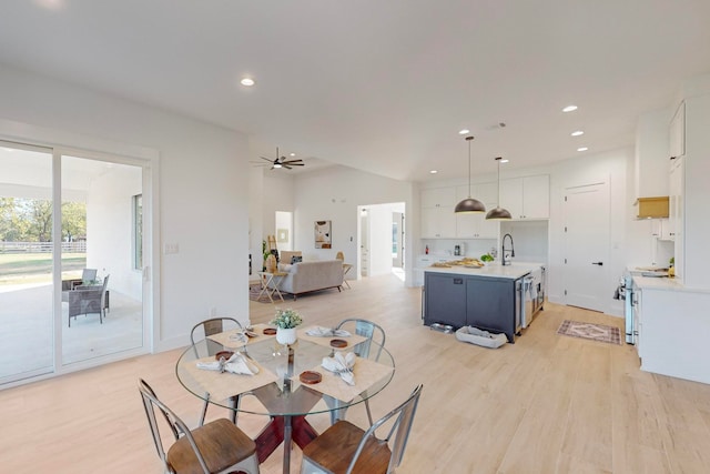 dining area with light wood-type flooring, lofted ceiling, and ceiling fan