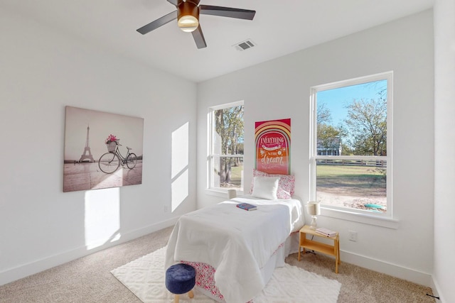 bedroom featuring light carpet, multiple windows, and ceiling fan