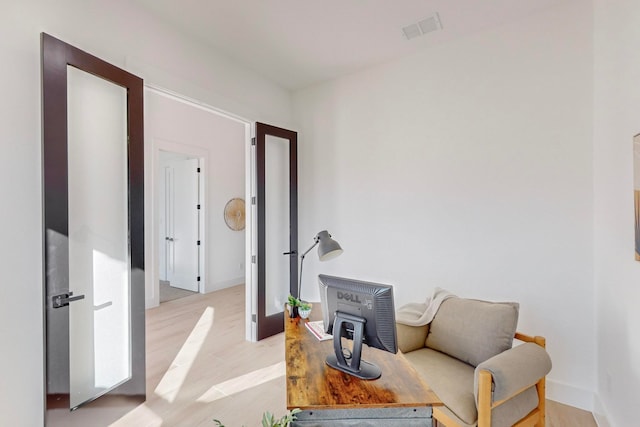 living area featuring french doors and light hardwood / wood-style flooring