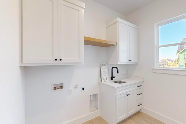 washroom featuring washer hookup, cabinets, sink, light hardwood / wood-style floors, and electric dryer hookup