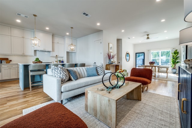 living room featuring ceiling fan and light hardwood / wood-style flooring