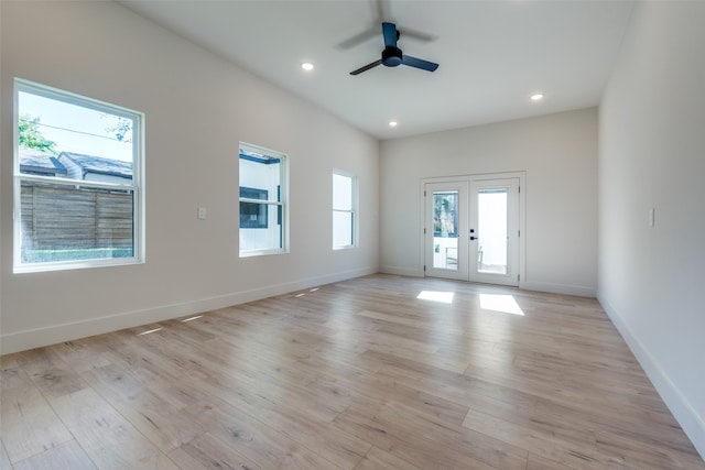 unfurnished room featuring a wealth of natural light, ceiling fan, light wood-type flooring, and french doors