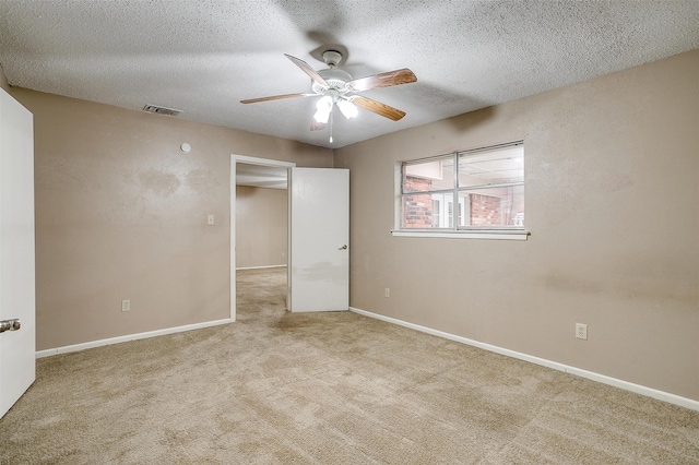 unfurnished bedroom featuring ceiling fan, a textured ceiling, and light carpet