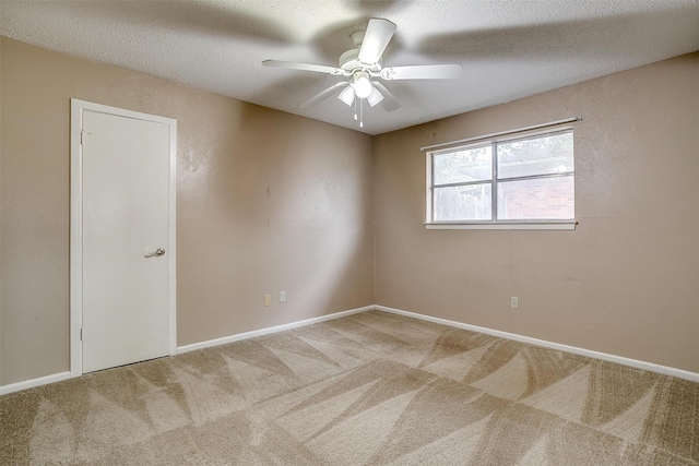 carpeted empty room featuring ceiling fan and a textured ceiling