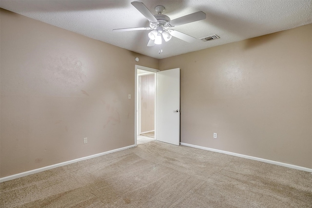 carpeted spare room featuring a textured ceiling and ceiling fan