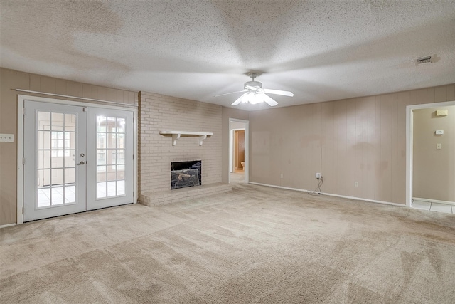 unfurnished living room featuring french doors, light colored carpet, a textured ceiling, and ceiling fan