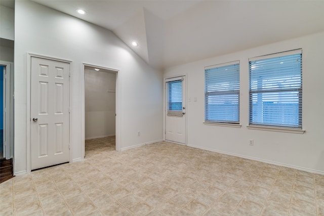 unfurnished room featuring vaulted ceiling