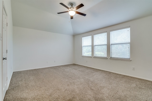 empty room with lofted ceiling, carpet flooring, and ceiling fan