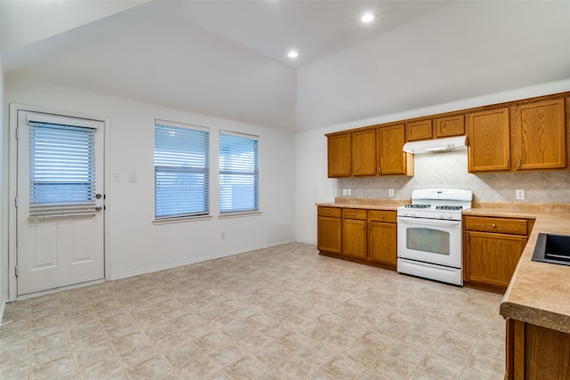 kitchen featuring high vaulted ceiling, decorative backsplash, white gas range, and a healthy amount of sunlight