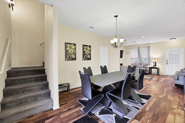 dining space with dark wood-type flooring and a notable chandelier