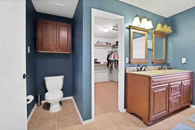 bathroom with tile patterned flooring, vanity, and toilet