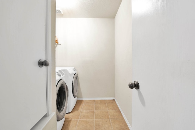 laundry room with washing machine and dryer and light tile patterned floors