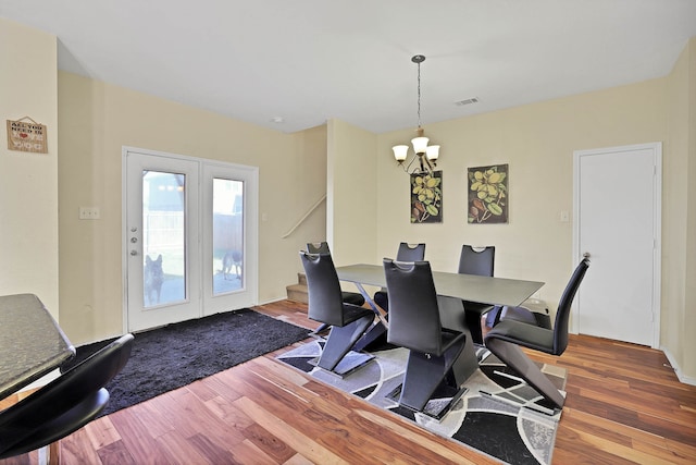 dining room with dark hardwood / wood-style flooring and a chandelier