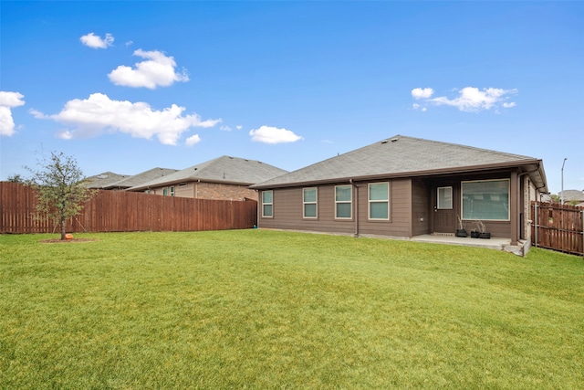 rear view of property featuring a patio and a yard