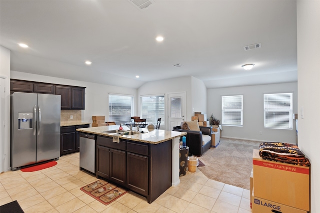 kitchen with sink, appliances with stainless steel finishes, an island with sink, dark brown cabinets, and light colored carpet