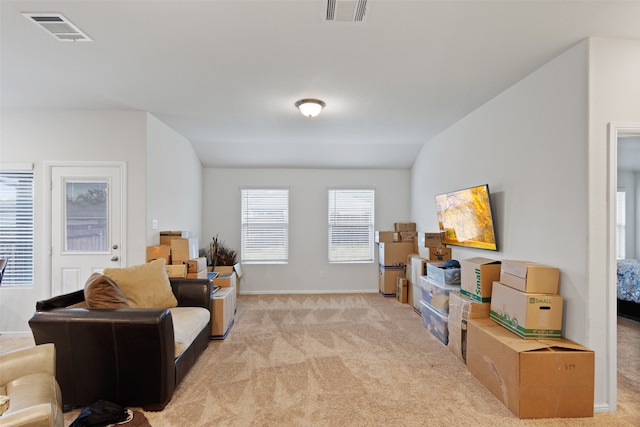 sitting room with vaulted ceiling and light colored carpet