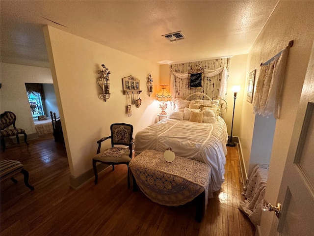 bedroom featuring wood-type flooring and a textured ceiling