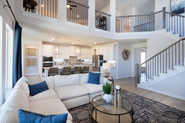 living room with light hardwood / wood-style flooring and a towering ceiling