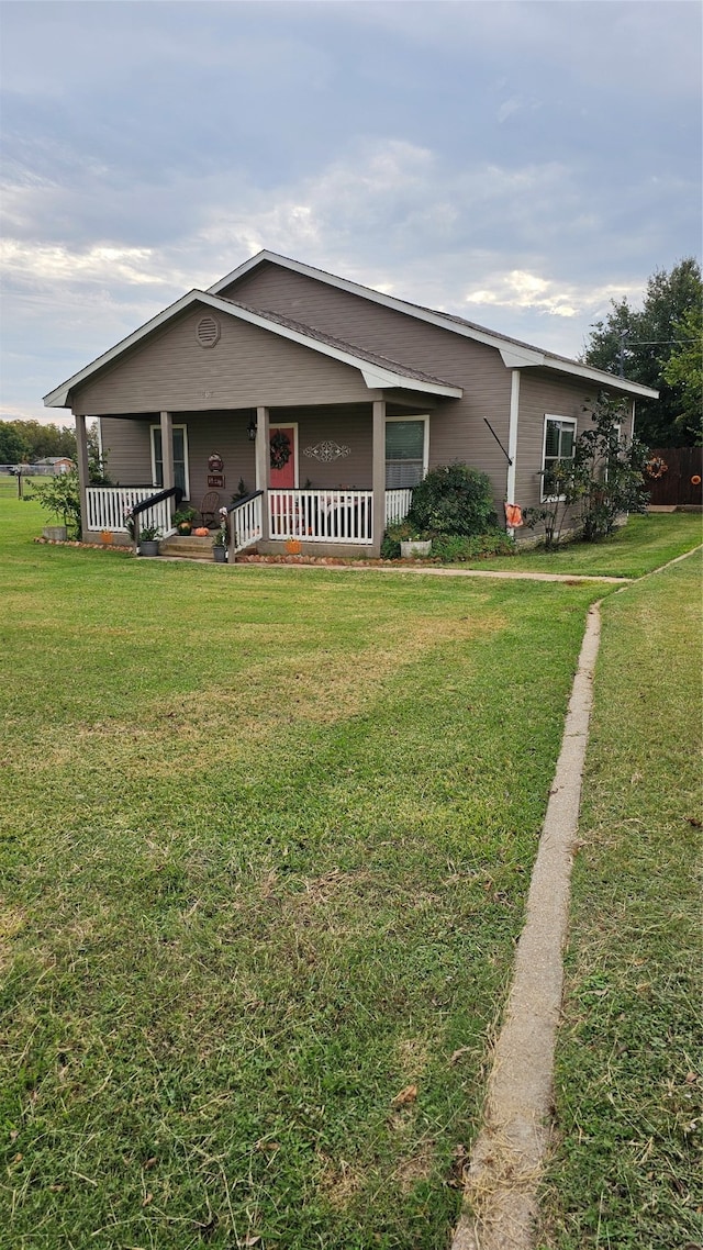 single story home featuring a front yard and covered porch